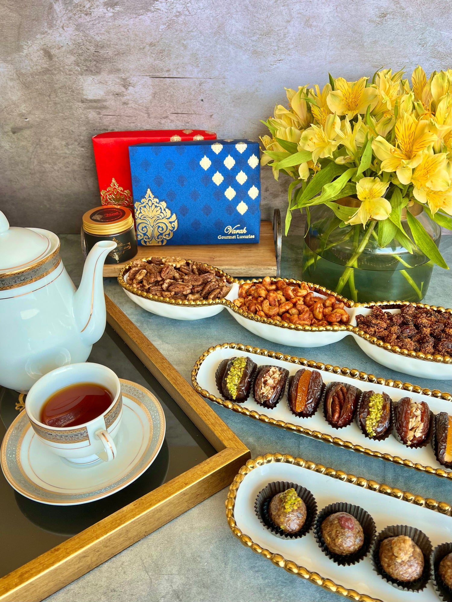 Paan Bites, Premium Stuffed Dates, Thai Cashews, Chili Garlic Pecans & Candied Nutes, served in a beautiful setting with a hot cup of tea